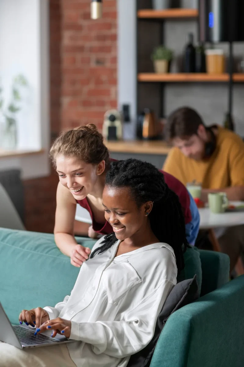 Femmes en train de travailler sur un canapé en souriant